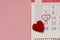Wall calendar marked with date 14 February in shape of heart, reminder of Valentine`s Day. Pink textured background for your text
