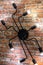 Wall chandelier in the form of a spider on a brick wall. Loft style