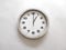 Wall clock isolated on a white wall, read at 1 o`clock.