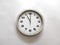 Wall clock isolated on a white wall, read at 11 o`clock.