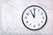 Wall clock show eleven o`clock on white marble texture. Office clock show 11pm or 11am