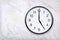 Wall clock show five o`clock on white marble texture. Office clock show 5pm or 5am