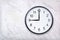 Wall clock show nine o`clock on white marble texture. Office clock show 9pm or 9am