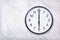 Wall clock show six o`clock on white marble texture. Office clock show 6pm or 6am