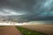 A wall cloud forms underneath a tornadic supercell thunderstorm on the plains.