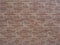 Wall with decorative mottled brown tiles with a pattern in the form of masonry. Not seamless texture