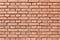 A wall with even rows of orange bricks. Texture blank background.