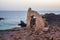 Wall with gate of a building demolished on a cliff facing the sea