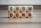 Wall made of cubes or dice with message showdown on wooden background