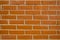 Wall with masonry made of bright orange brick close up