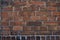 Wall of an old brick house with spots of white paint