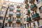 wall of an old high-rise building with green balconies.