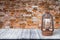 Wall of old red bricks. Background. View from dark wooden gangway, table or bridge with vintage kerosene lamp. Collage