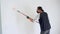 Wall painting technique with a roller. Person applying color to a wall