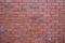 A wall of red brick aging by time and faded by wheather