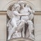 Wall sculpture of two winged angels playing with musical instrument, located in museums district, downtown of Vienna, Austria