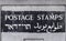 A wall sign for postage stamps at the post office branch in Jerusalem, Israel. English, Hebrew and Arabic languages