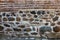 Wall stones and reddish bricks texture background outside.