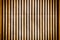 Wall of thin wooden slats. Vertical parallel plates. Background with vignette.