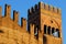 Wall and tower of the ancient medieval palace of King Enzo, illuminated by the sun and with the background of blue sky at Bologna