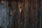 A wall of a wooden building, boards blackened with old age.