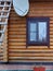 wall of a wooden house with a satellite dish