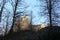 Walls of castle Girls Stone behind trees during sunset