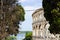 Walls of the Pula Arena, the only remaining Roman amphitheatre entirely preserved, between some trees in Pula, Croatia, with