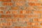 Walls are textured red clay bricks with pattern. Background of a new brick house with cement