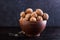 Walnut in a clay bowl and a gout on a concrete background