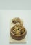 Walnut kernel halves, in a wooden bowl on white background. Close-up