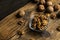 Walnut in a smale plate with scattered shelled nuts and whole nut which standing on a wooden vintage table. Walnuts is a