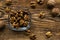 Walnut in a smale plate with scattered shelled nuts and whole nut which standing on a wooden vintage table. Walnuts is a