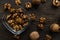 Walnut in a smale plate with scattered shelled nuts and whole nut which standing on a wooden vintage table. Walnuts is a