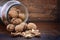 Walnuts in glass jar on wood table.