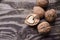 Walnuts on a grey textured wooden table. Assortment of nuts isolated on rustic old wooden background and splintered walnut with he
