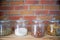 Walnuts, pasta, grains and salt in glas jars in modern loft design kitchen in front of bricked wall, cooking concept