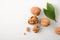 Walnuts in shell and broken showing seeds on white table top