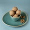 Walnuts in small turquoise ceramic bowl on plate