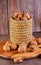 Walnuts in a wicker basket, whole and finely chopped, next to the filling and shells on a wooden background. Home storage of