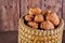 Walnuts in a wicker basket, whole and finely chopped, next to the filling and shells on a wooden background. Home storage of