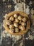 Walnuts in a wooden bowl on wooden rustic background, top view