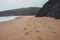 Wandering along the Fisherman Trail in the Algarve region of southwestern Portugal. Human footprints in the sandy surface