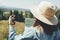 Wanderlust and travel concept. Stylish hipster girl holding map and compass, traveling in sunny mountains. Woman in hat exploring