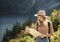 Wanderlust and travel concept. Stylish traveler girl in hat looking at map, exploring woods