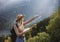 Wanderlust and travel concept. Stylish traveler girl in hat looking at map, exploring woods