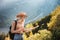 Wanderlust and travel concept. Stylish traveler girl in hat looking at map, exploring woods