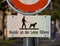 The waning sign in German language says that dogs should be kept on leash