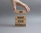 We want your feedback symbol. Wooden blocks with words We want your feedback. Beautiful grey background. Businessman hand. We want
