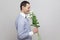 He wants to give a flowers. Side view portrait of charming pleasure romantic young man in blue shirt holding bouquet of white flow